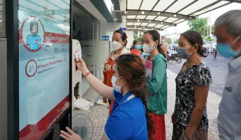 Nhân viên y tế Bệnh viện Thống Nhất hướng dẫn người dân quẹt thẻ Tekmedi đăng ký khám chữa bệnh